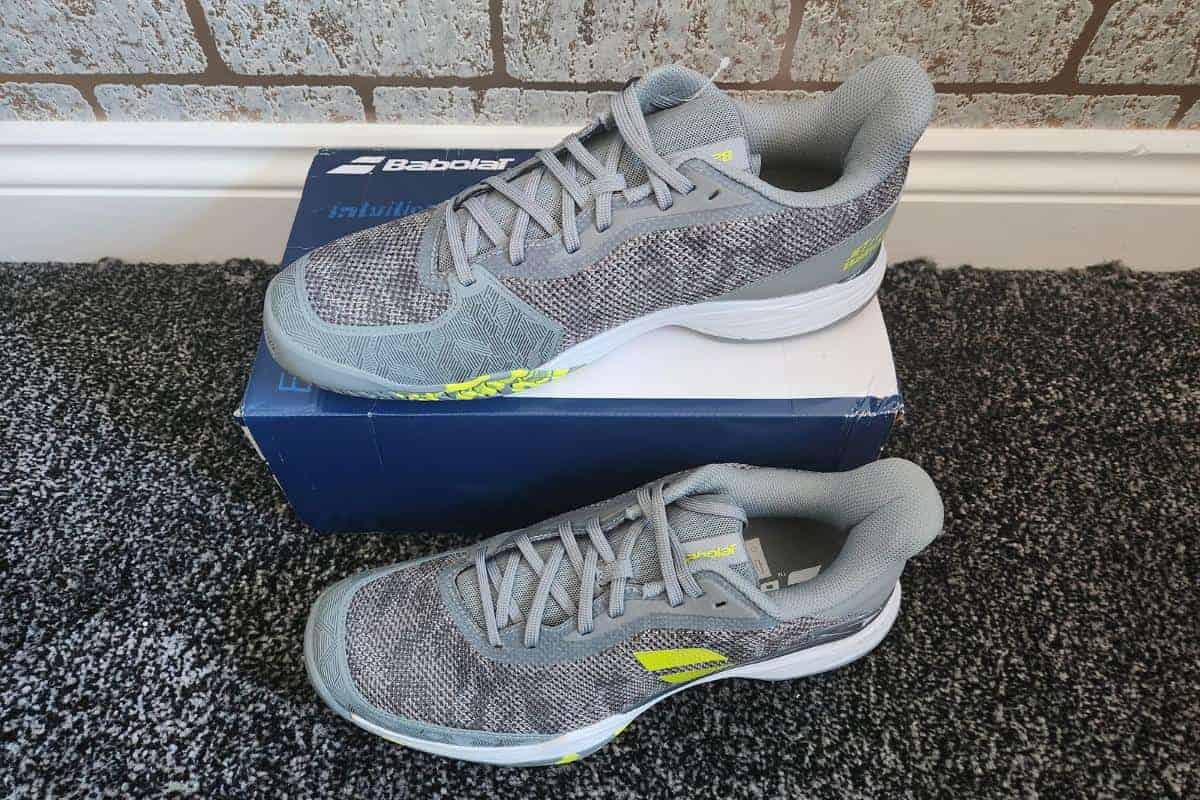 Tennis shoes in a grey colour with flashes of neon green.