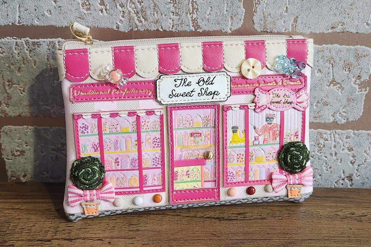 The Old Sweet shop purse with pink and colourful design showing small jars of sweets.