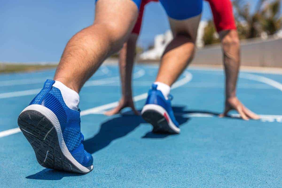 Man on running track read to start running.