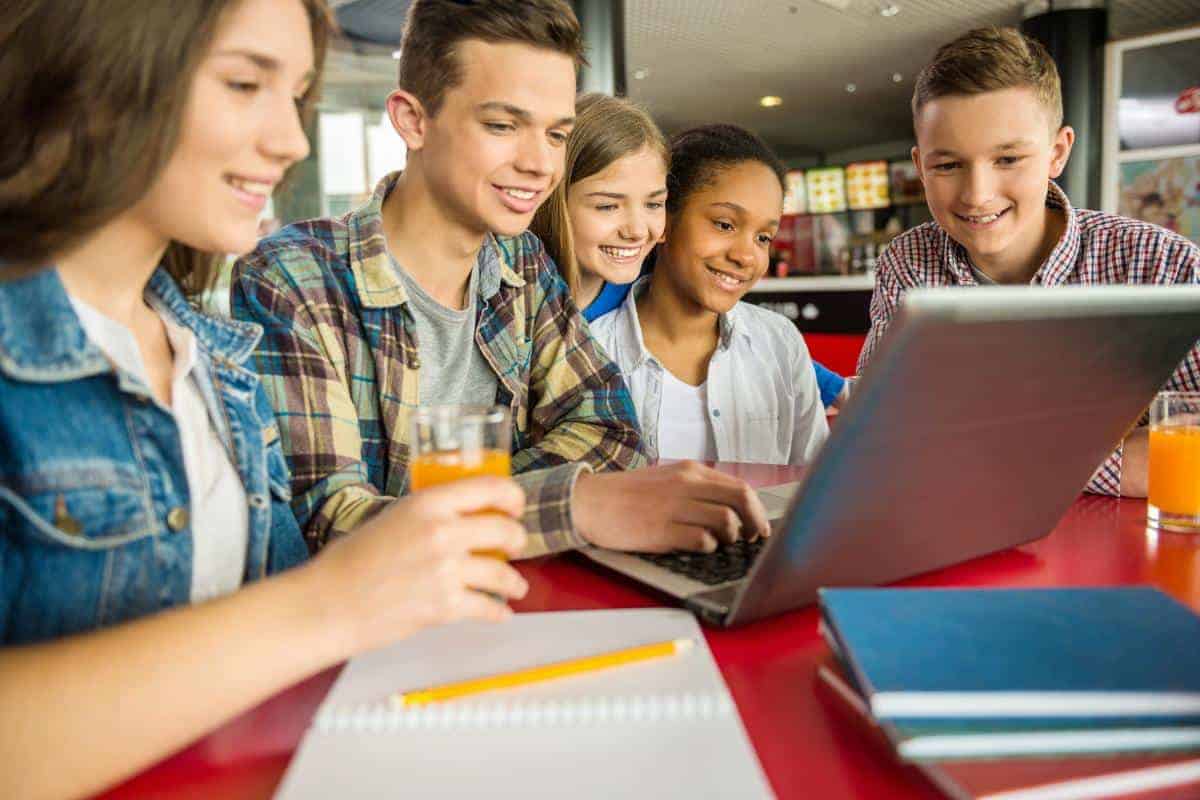 teenagers around a laptop planning fundraising activities.