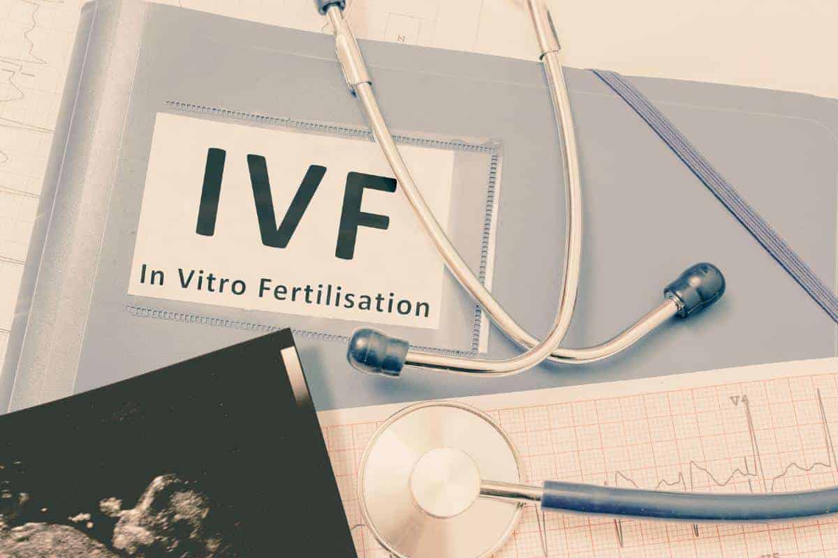 A stethoscope and ultrasound image rest on documents labeled "IVF In Vitro Fertilization," subtly hinting at the potential benefits of weight loss for IVF success.