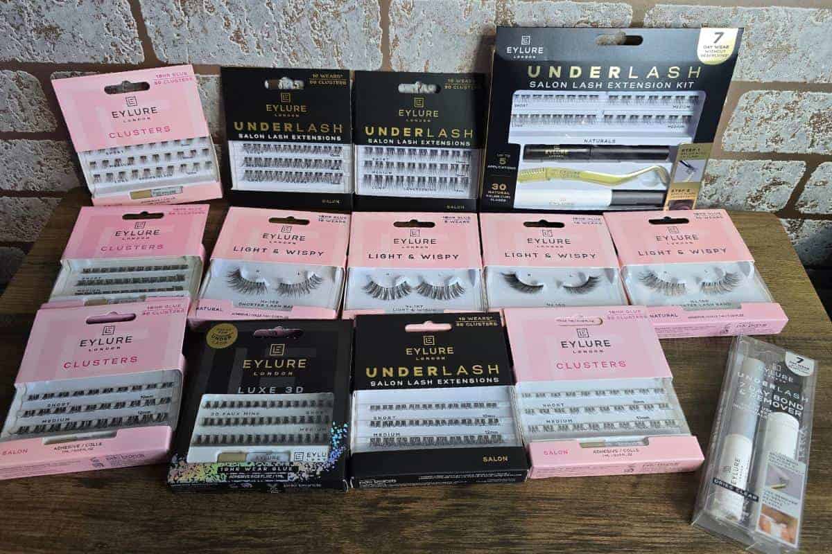 Assorted Eylure false eyelashes and lash extension kits, perfect as a lovely gift, are displayed against a brick background.