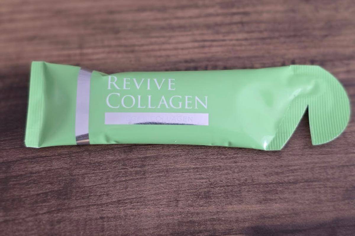 A green packet of Revive collagen vegan labelled "Revive Collagen" lies on a wooden surface.