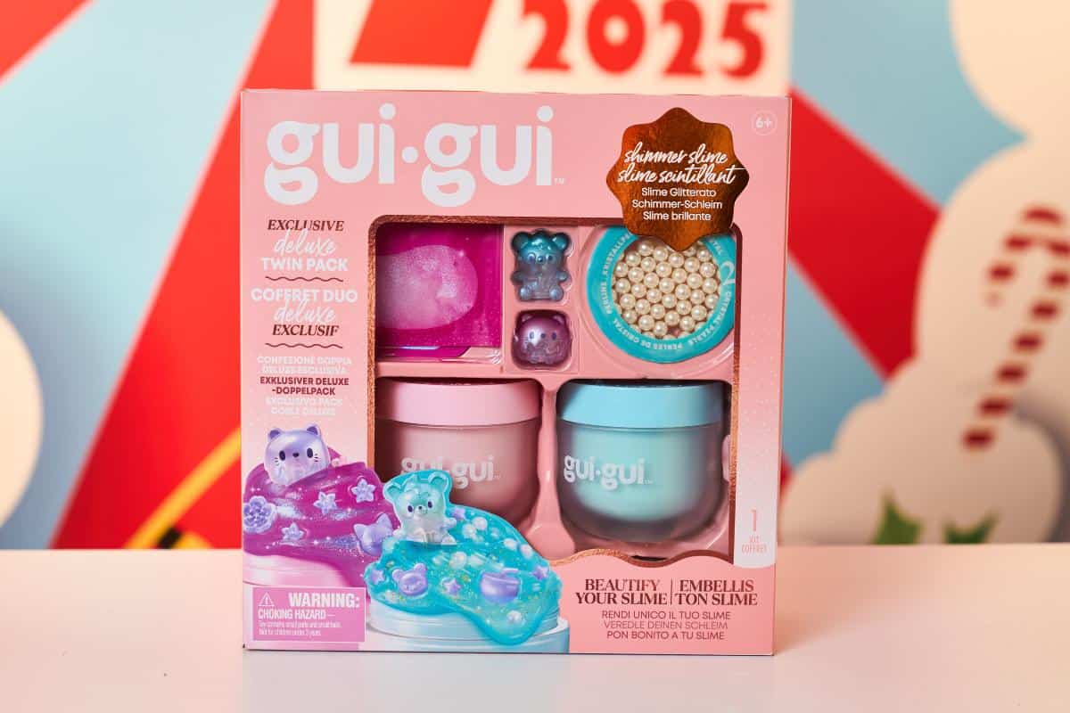 A boxed set of gui-gui deluxe slime kit featuring two pastel-colored containers, sparkly beads, a tiny bear figure, and purple-blue slime. Packaging is pink with playful graphics—perfect for kids toys or Top Toys 2025 Christmas gifts.