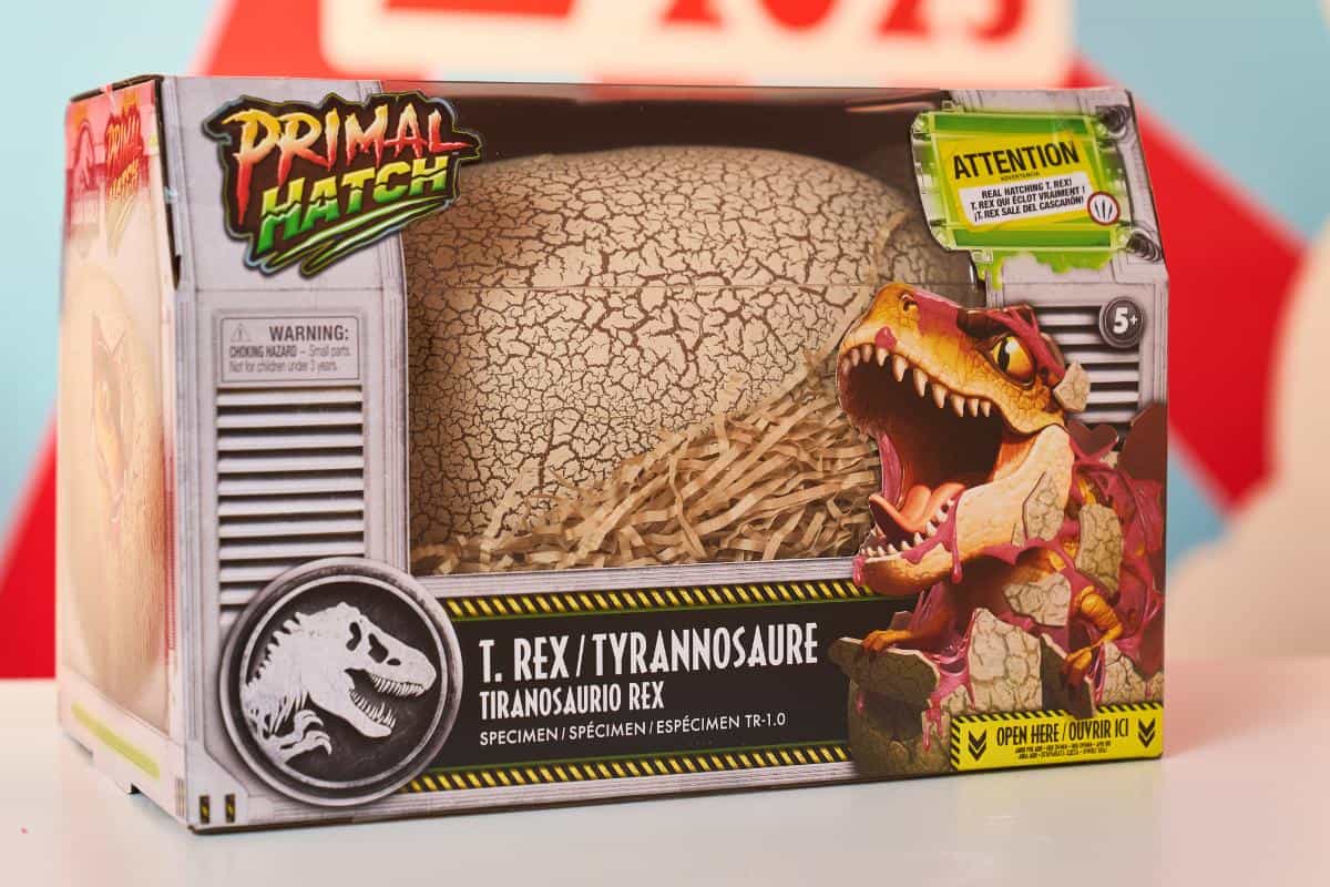 A Primal Hatch T. Rex/Tyrannosaurus Rex toy box featuring a cracked dinosaur egg, straw, and an illustrated roaring T. Rex—one of the Top Toys 2025 that's sure to be on every kids’ Christmas list! Packaging includes warnings and suits ages 5 and up.
