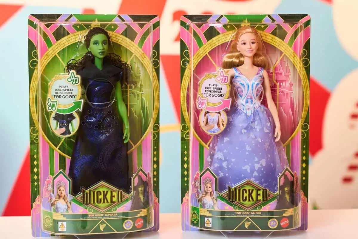 Two boxed dolls from the musical "Wicked"—Elphaba and Glinda—in colorful packaging with "Wicked" branding. These enchanting figures make a magical addition to any Christmas List and are sure to be among the Top Toys 2025 for kids.