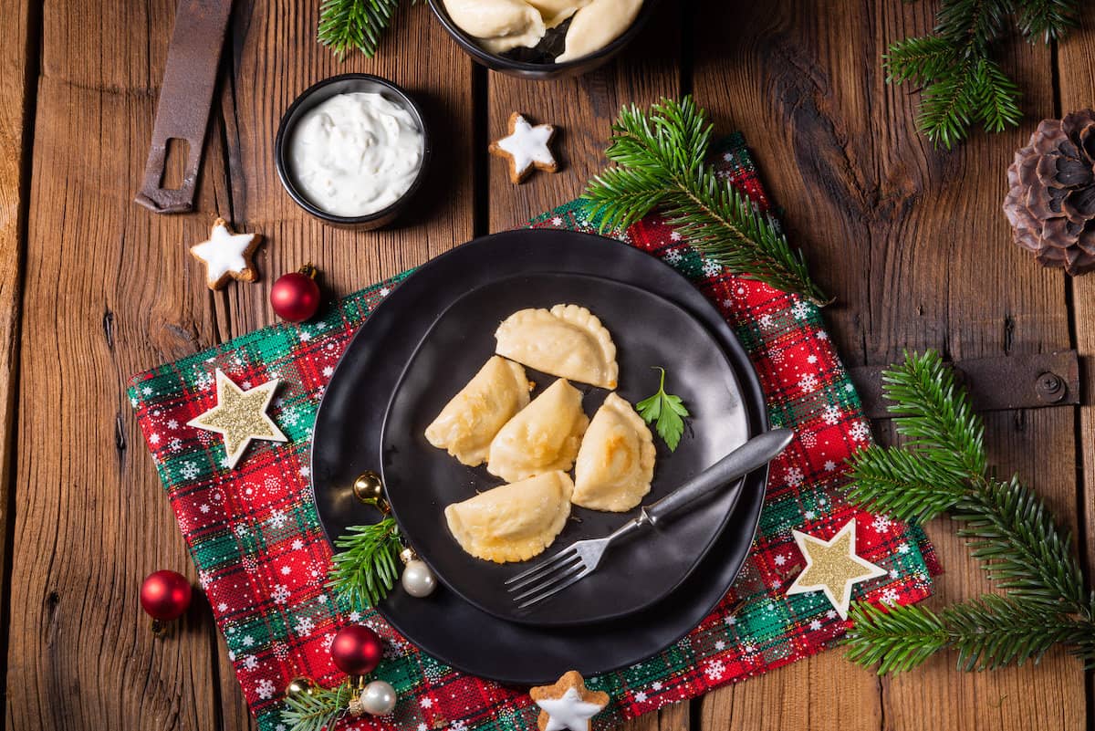 Polish mushroom and sauerkraut pierogi on a black plate.