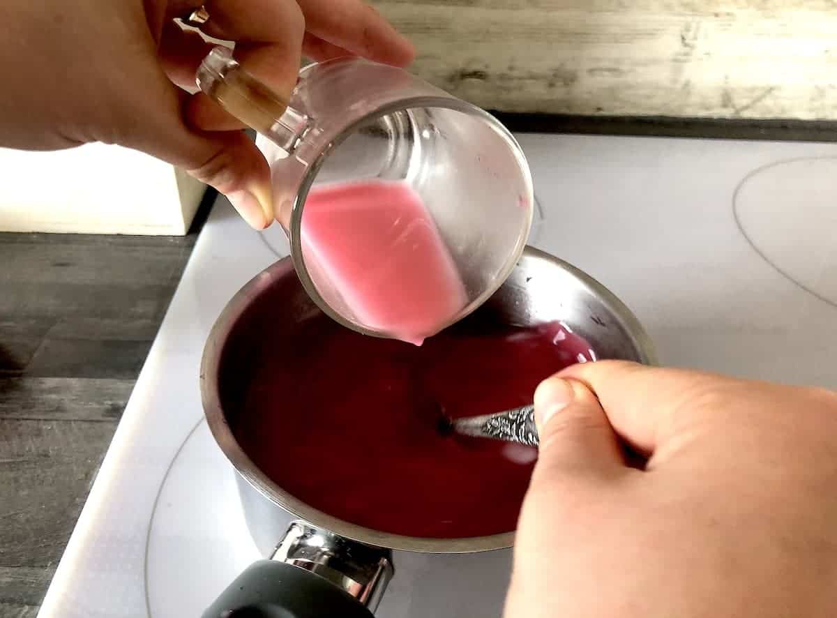 Cup pouring starch mix to kompot pot.