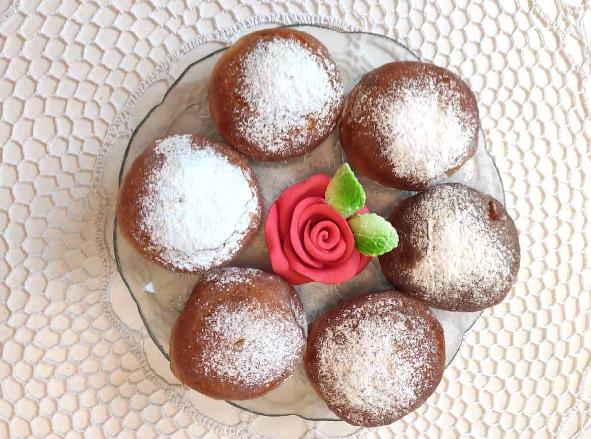 Paczki dusted with powdered sugar.