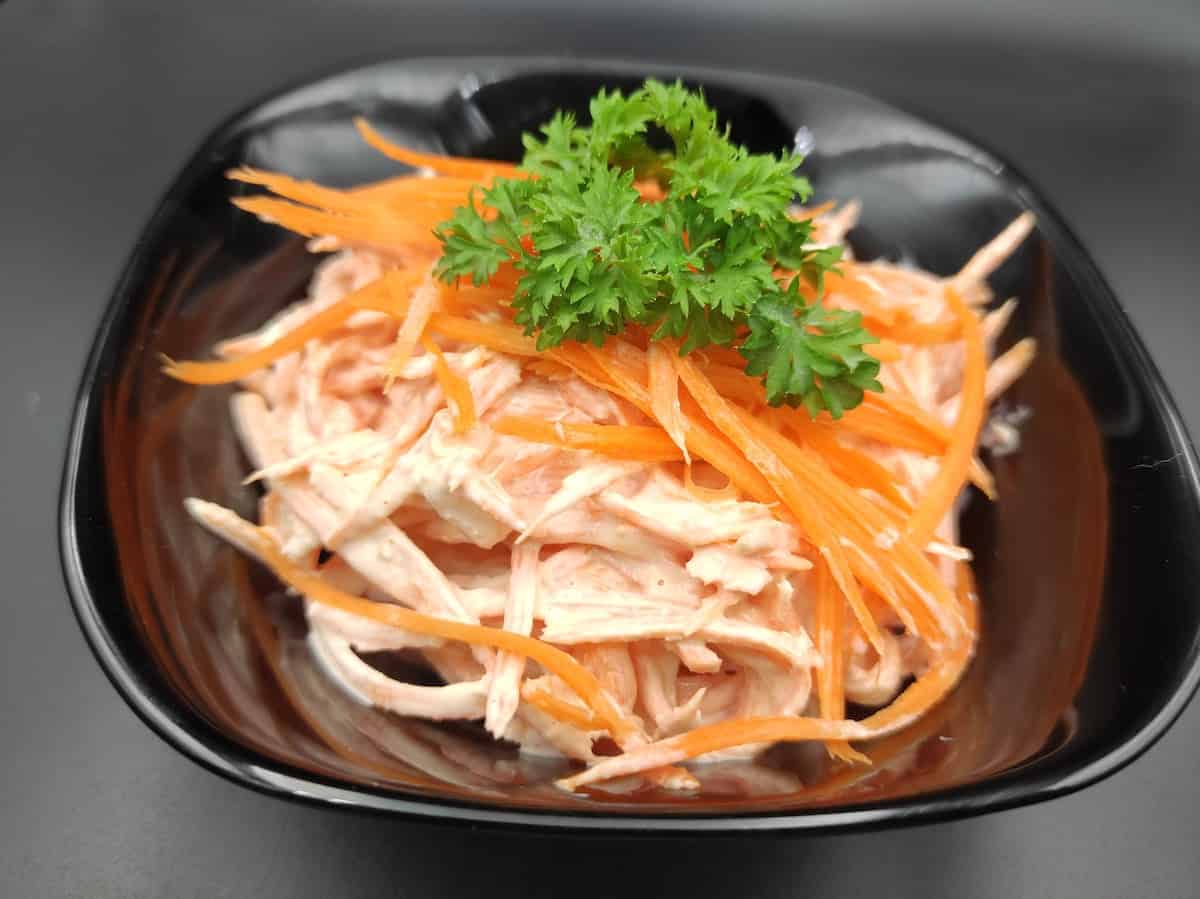 surowka z marchewki polish carrot salad in a black bowl.