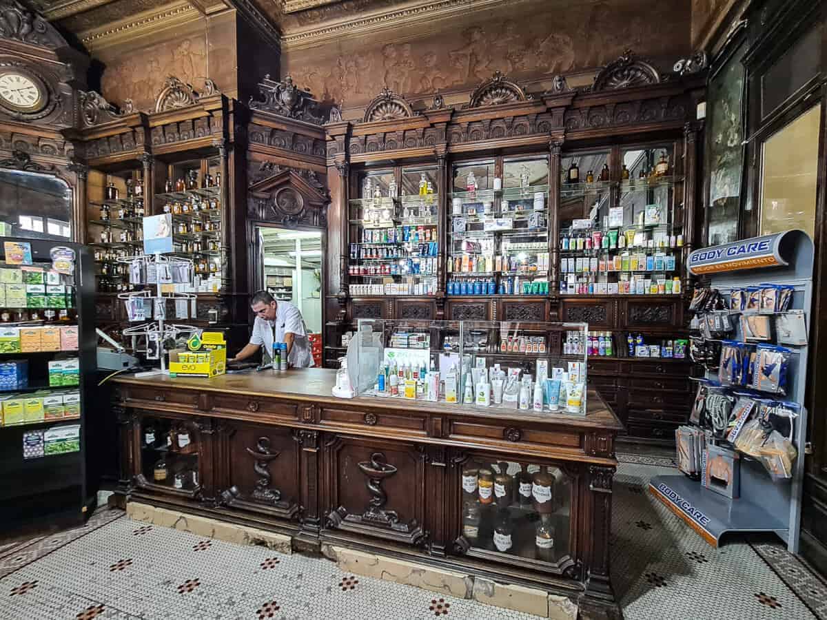 Interior of Farmacia Estrella, a hidden gem in Buenos Aires known for its stunning antique wooden cabinetry, vintage decor, and rich history. The shelves are stocked with pharmacy items, and the ornate design highlights its status as one of the oldest and most unique pharmacies in the city, offering an off-the-beaten-path experience for visitors.