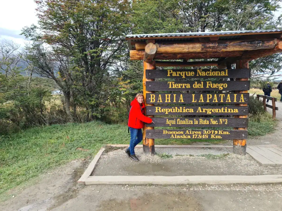 Traveler at Bahía Lapataia sign in Tierra del Fuego National Park, Ushuaia, Argentina