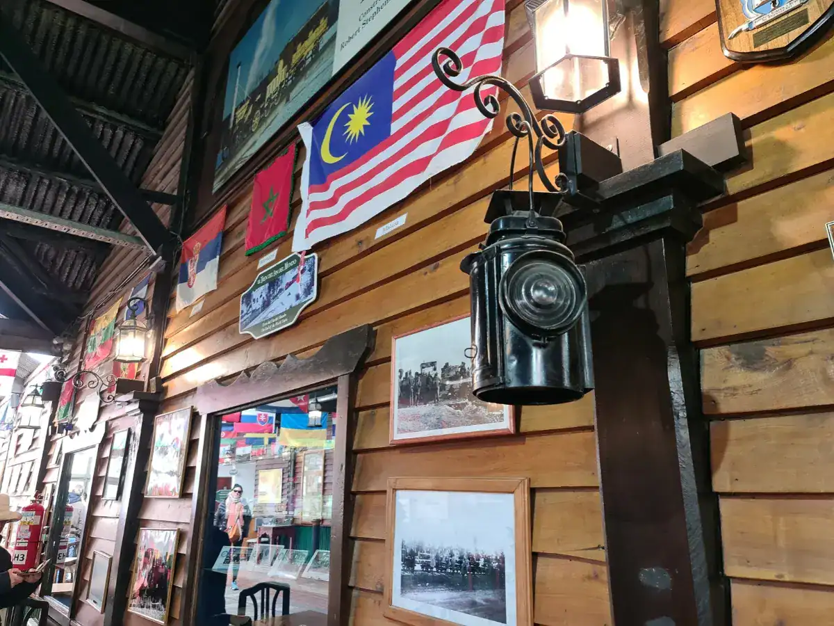 Interior of the End of the World Train station museum in Ushuaia with vintage lantern, flags, and historic photos