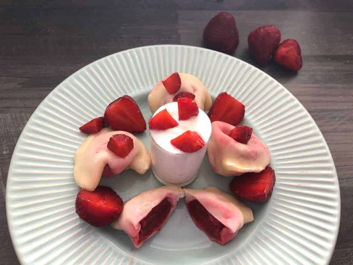 Strawberry pierogi in a blue plate. 