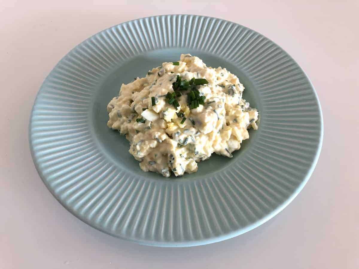 Polish egg salad in a blue plate.