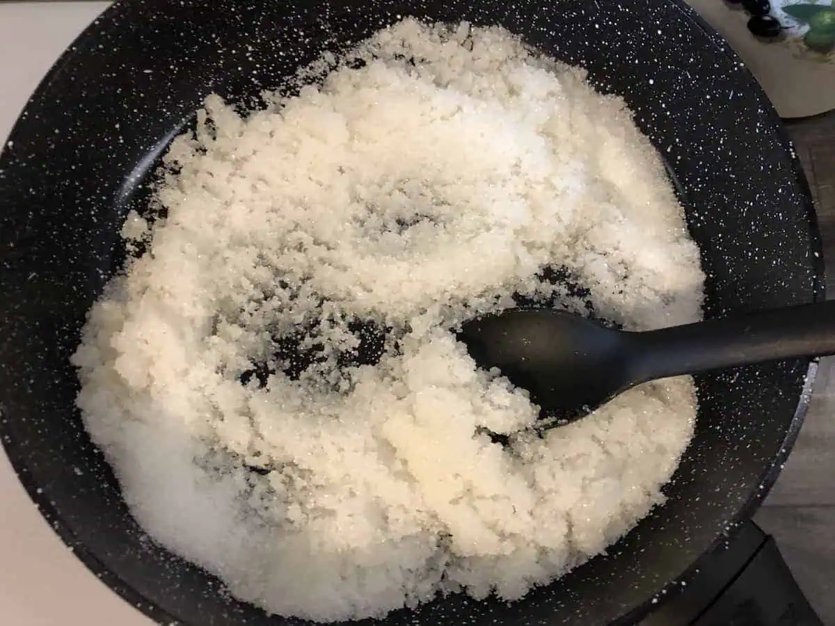 Sugar in a black frying pan.