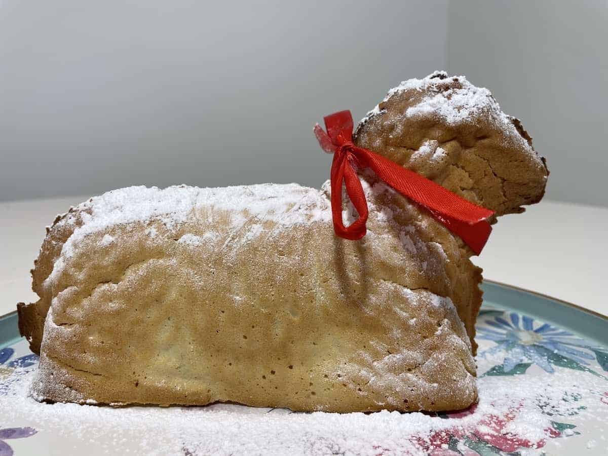 Lamb cake with red ribbon and icing sugar.