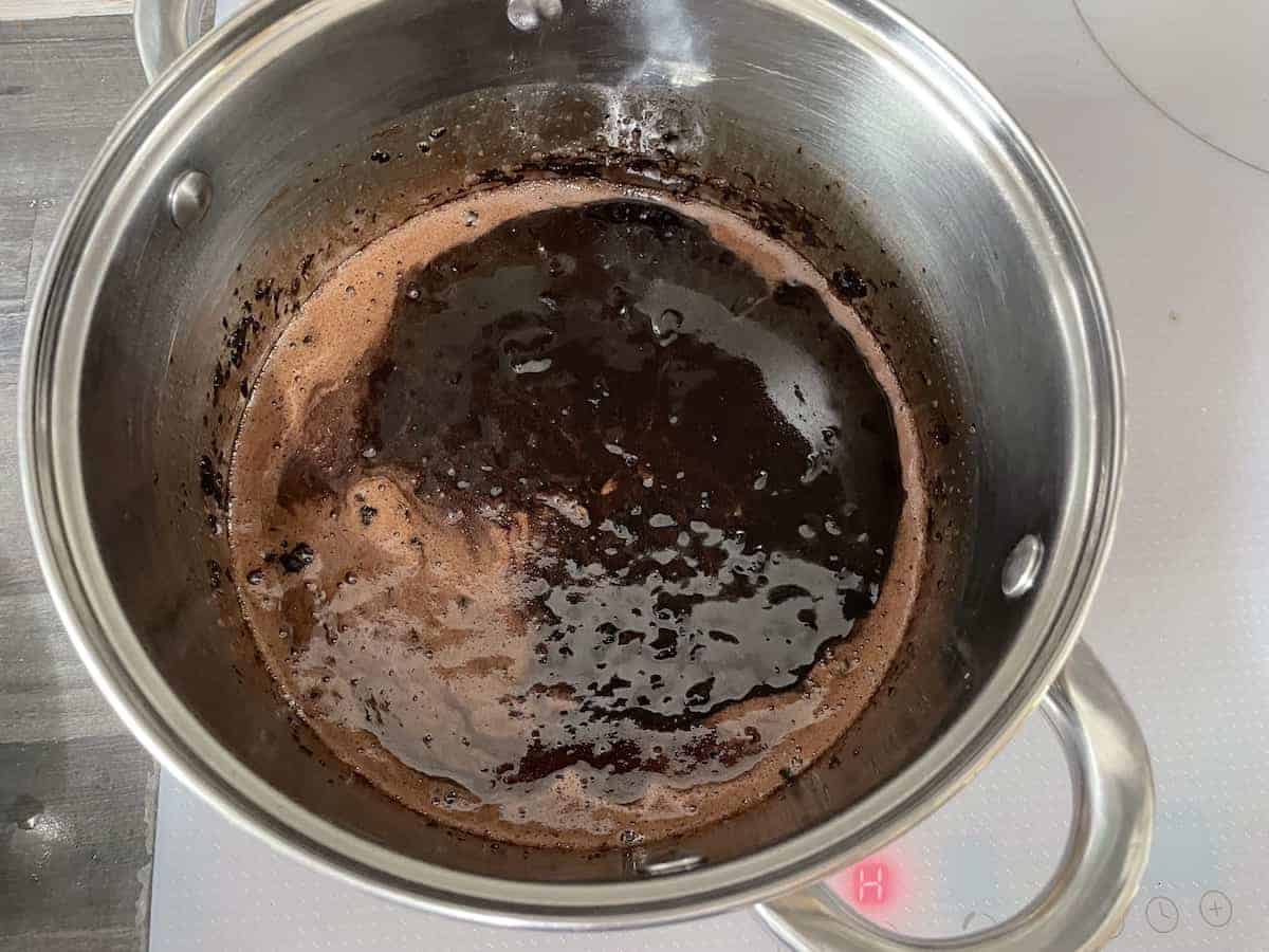 Cocoa powder mixed with butter, sugar and water on the stove.