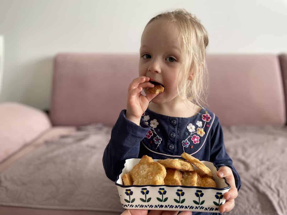 Child holding a bowl of Amoniaczki.