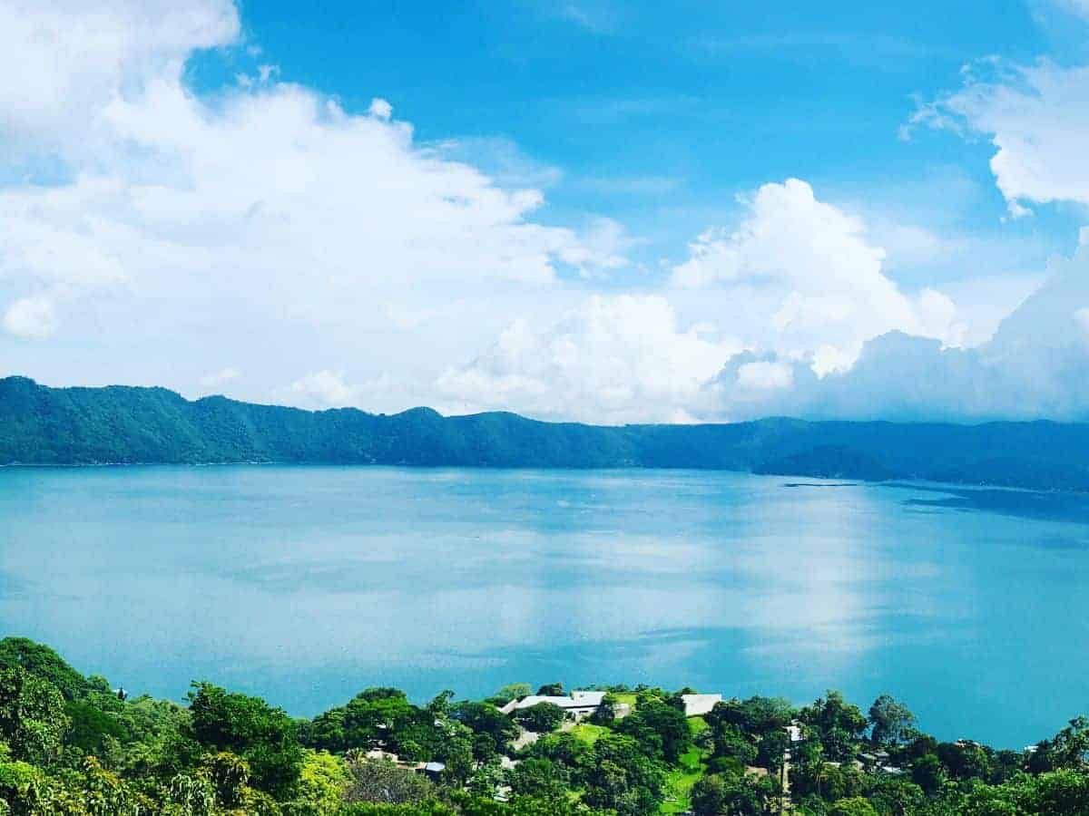 Reasons Not to Skip Lake Coatepeque, El Salvador. Reasons Not to Skip Lake Coatepeque, El Salvador. Image of blue lake in a crater surrounded by green trees, beneath a blue sky with white clouds