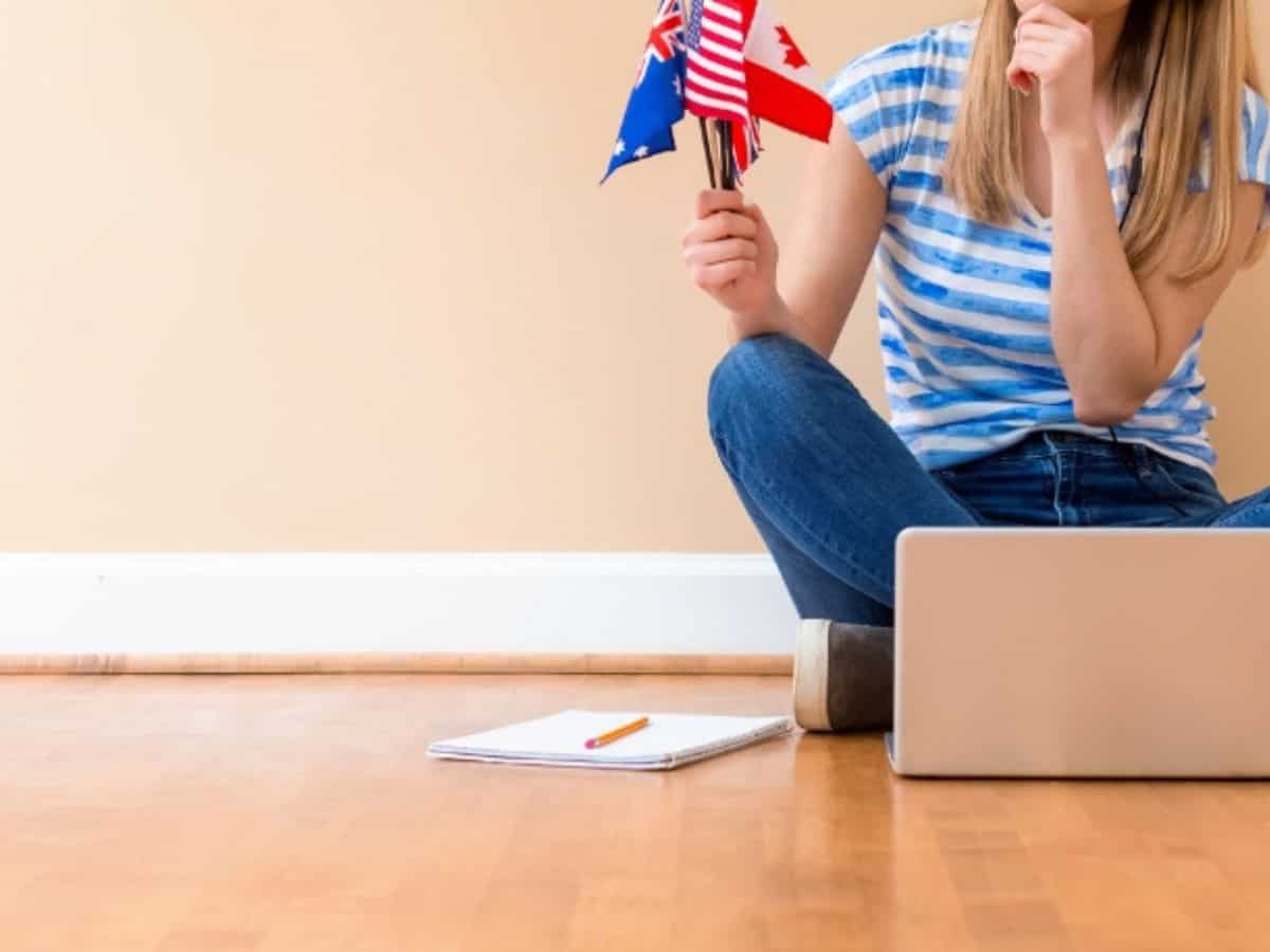 Teach English Online Teach English Online - teacher sitting cross legged on floor in front of laptop teacheing English