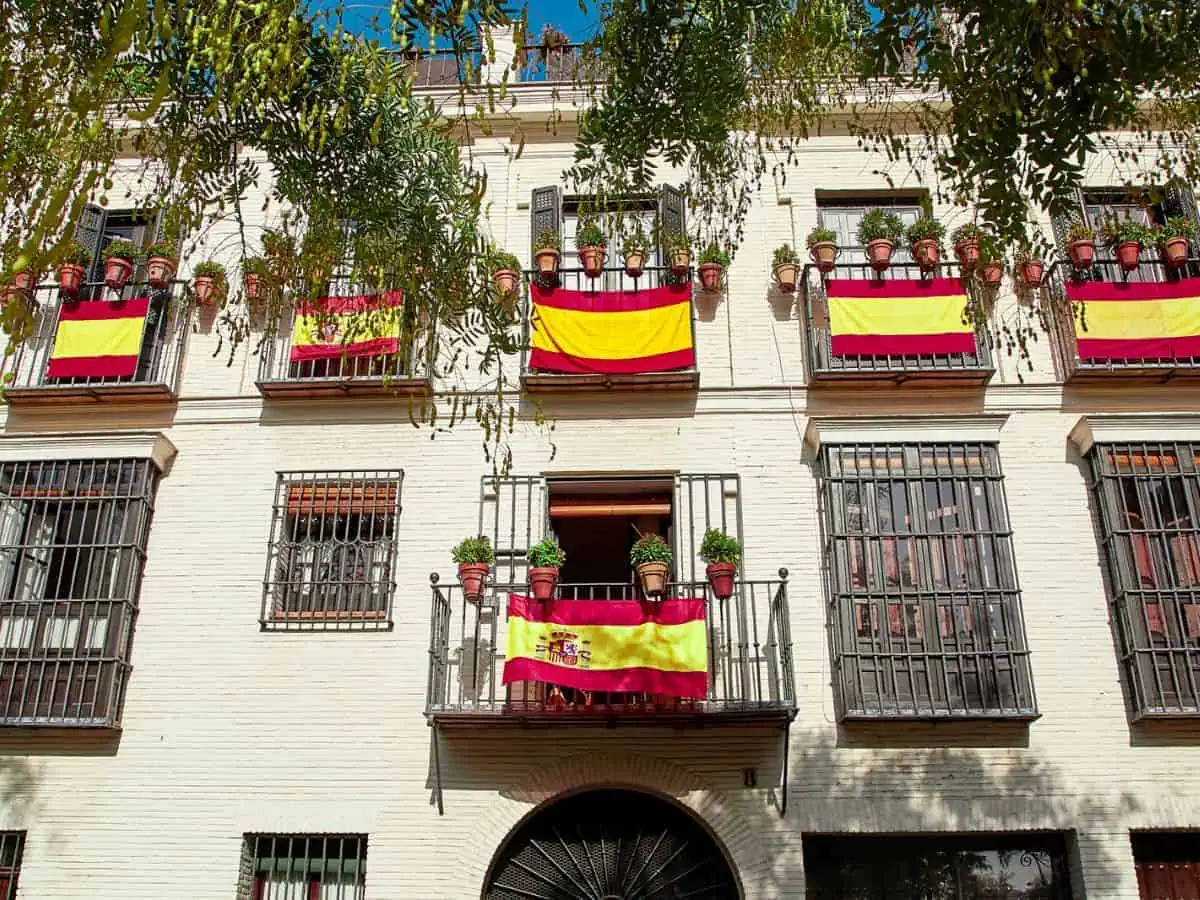 Pros and Cons of Living in Spain. Flags Hanging from Balconies. Pros and cons of living in Spain. Spanish flags hanging on apartment balconies