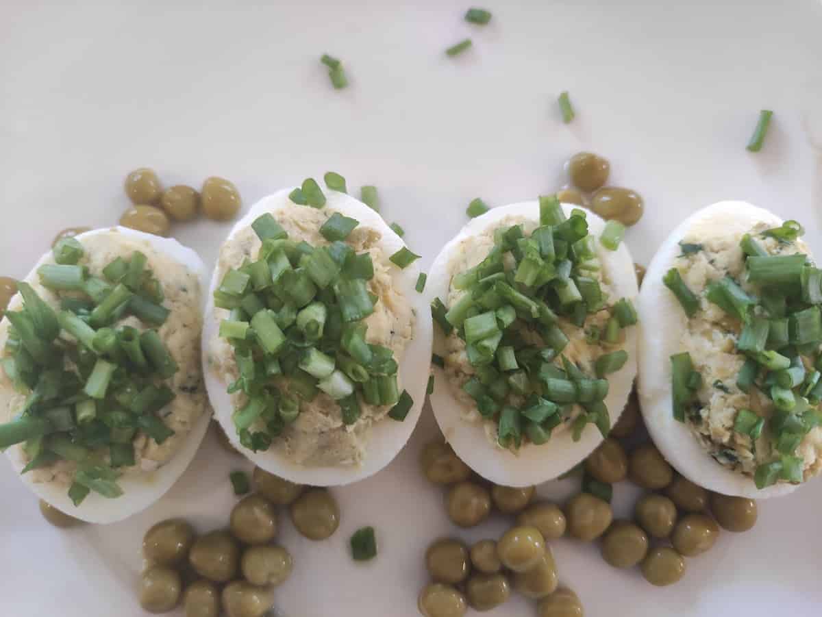 Deviled eggs with peas and parsley.