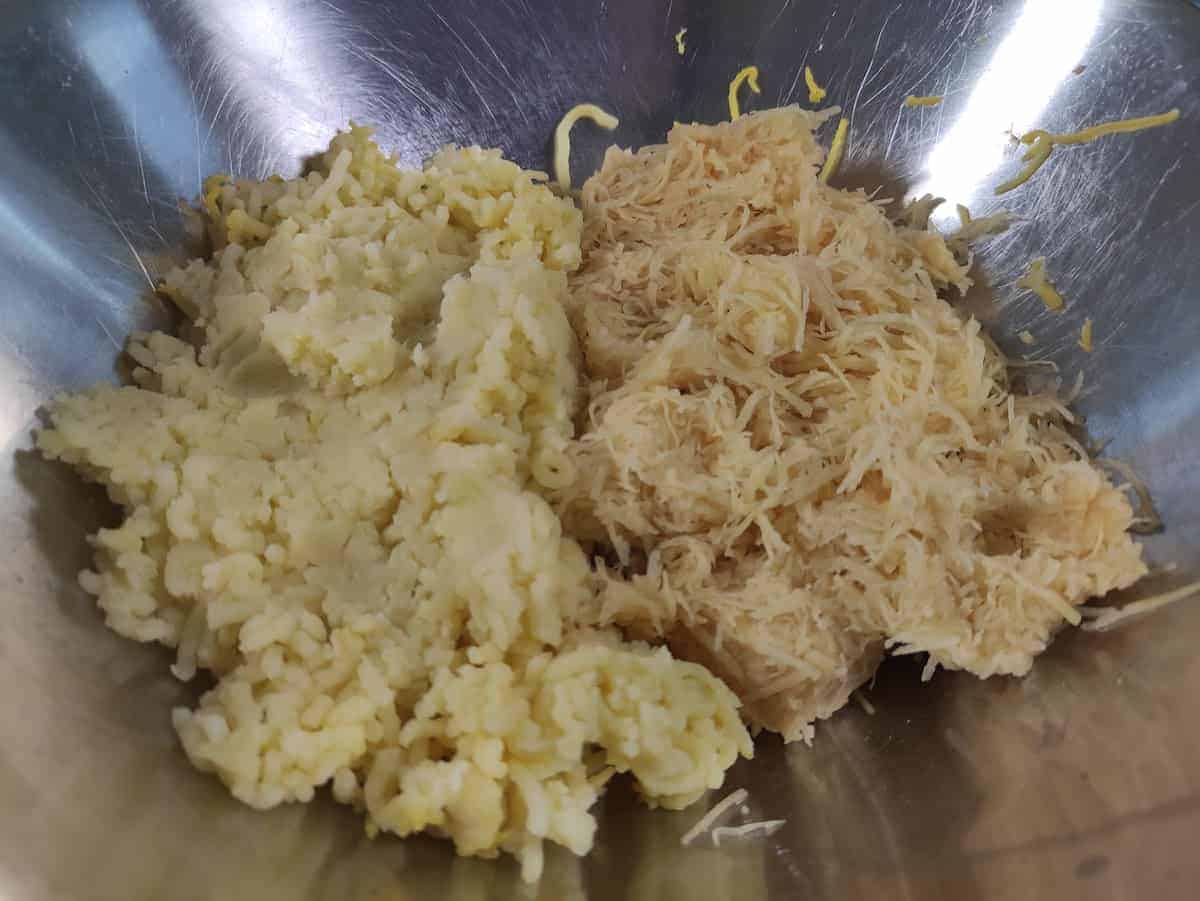 Mashed and grated potatoes in a bowl.