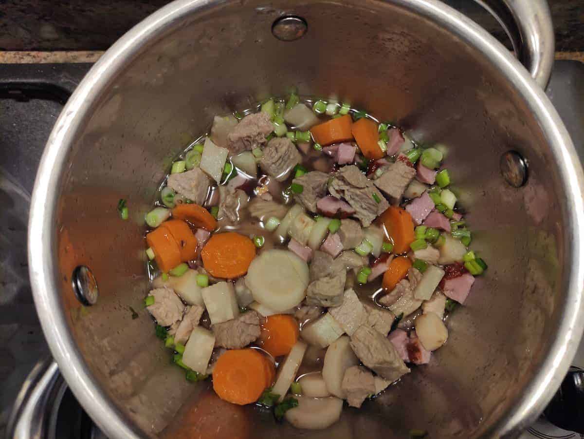 adding all the ham soup ingredients into the pot 