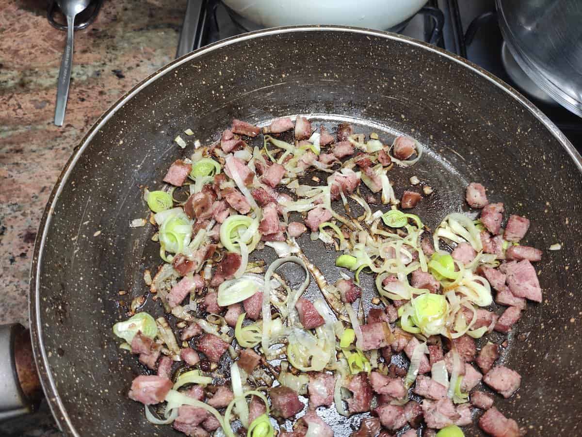 Fry the sausage for Polish red cabbage soup.