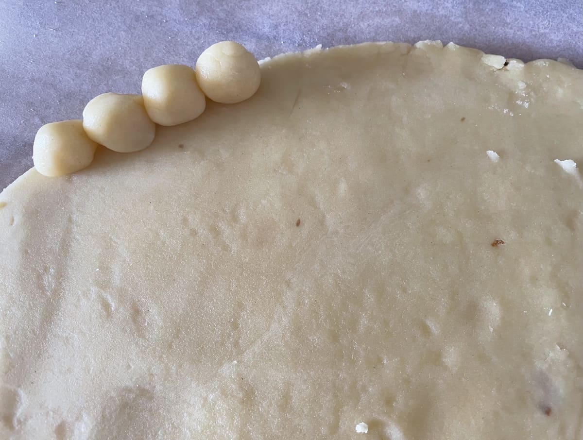 Forming a frame with small balls of dough.