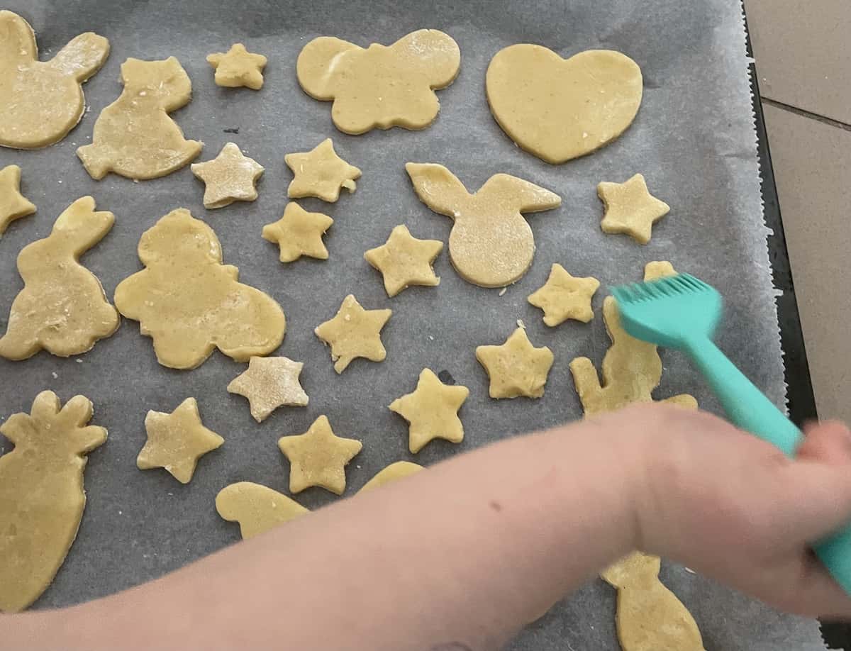 Brushing the cookies with egg white.