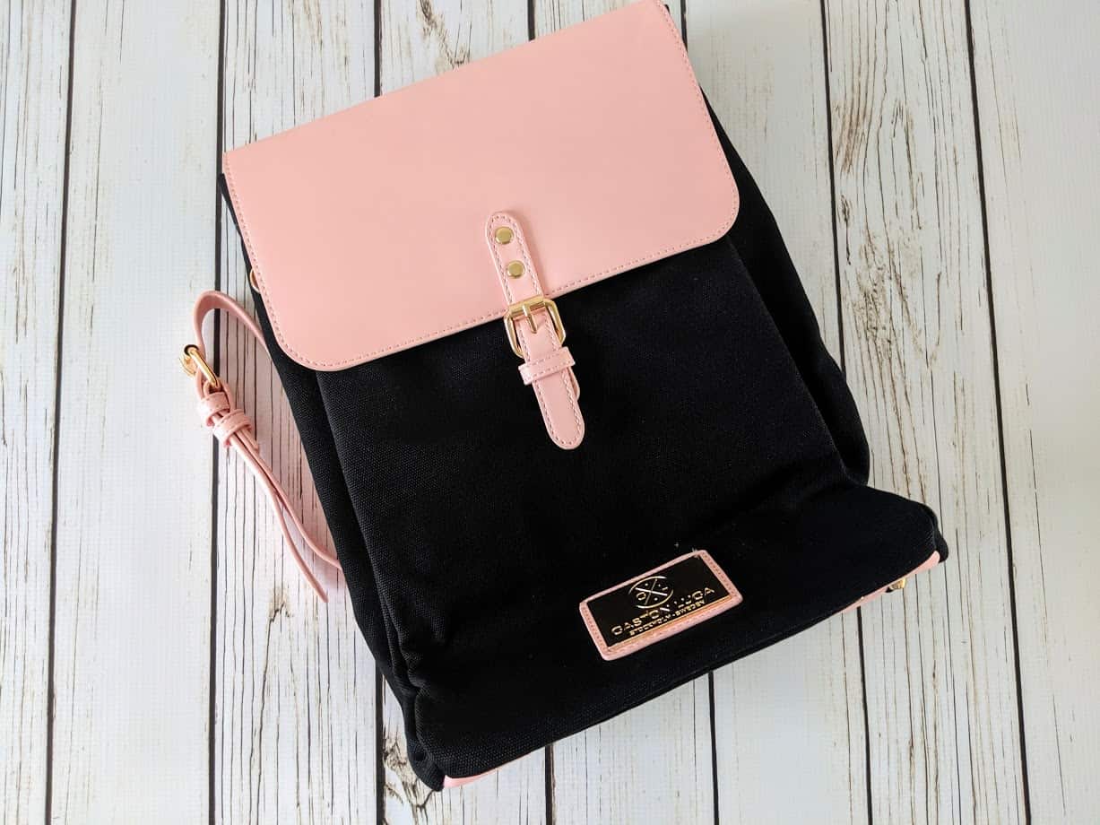 A pink and black backpack on wooden surface