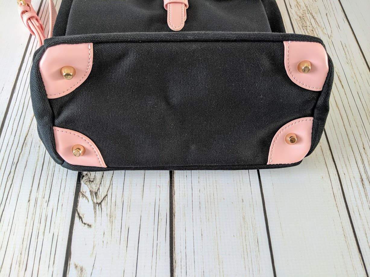 A pink and black backpack on a wooden surface