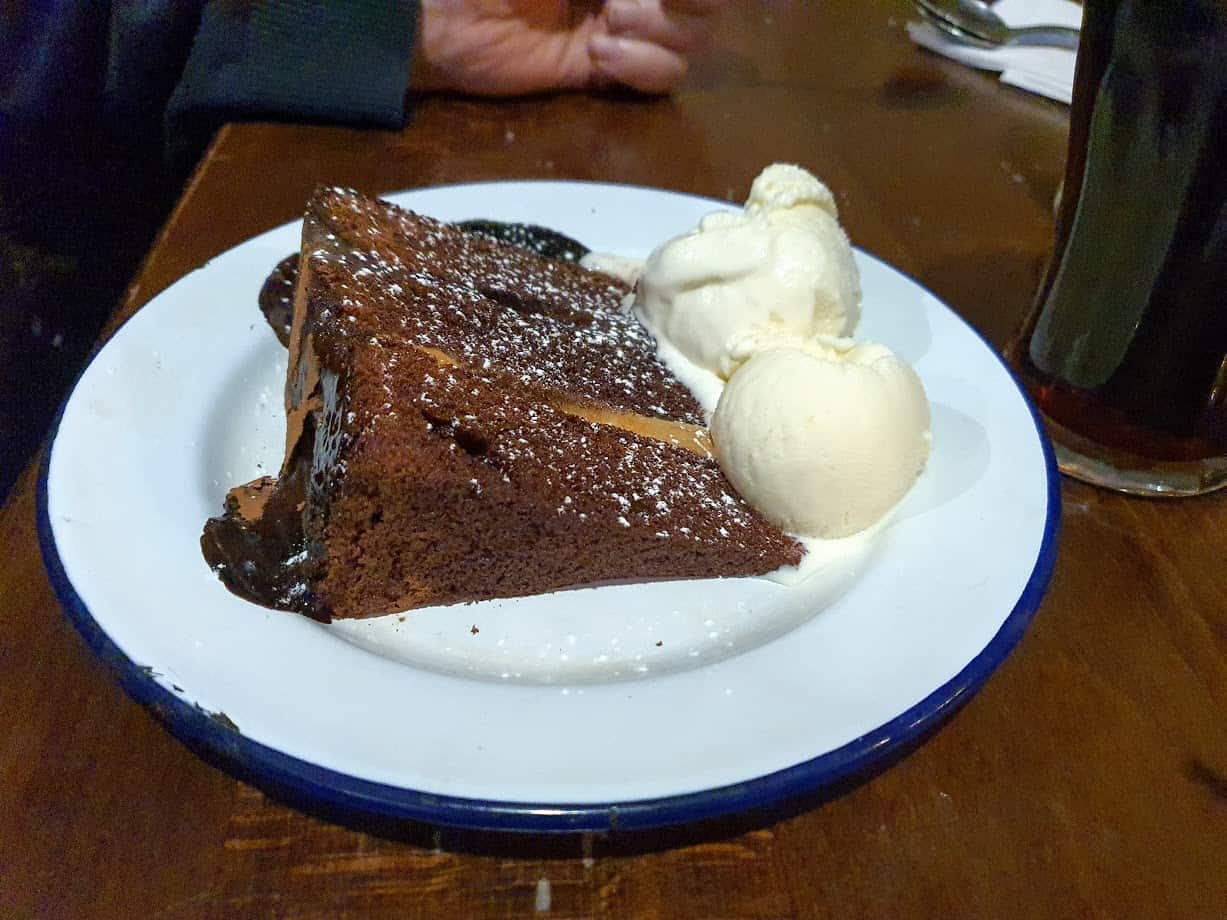 Chocolate fudge cake and ice cream on white plate with blue rim from the Horn in Hand, Nottingham