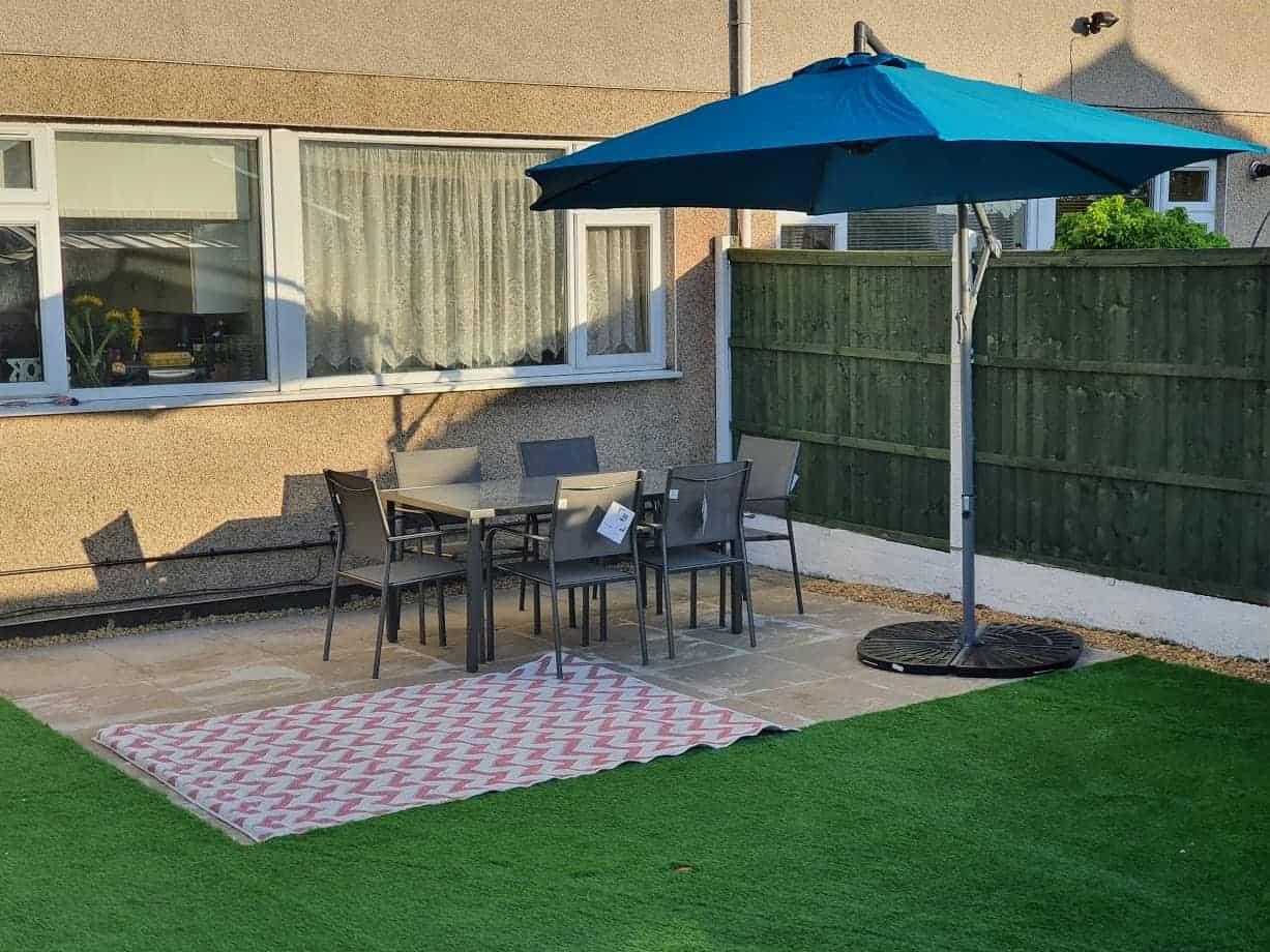 Garden renovation with seating area and blue parasol and stand
