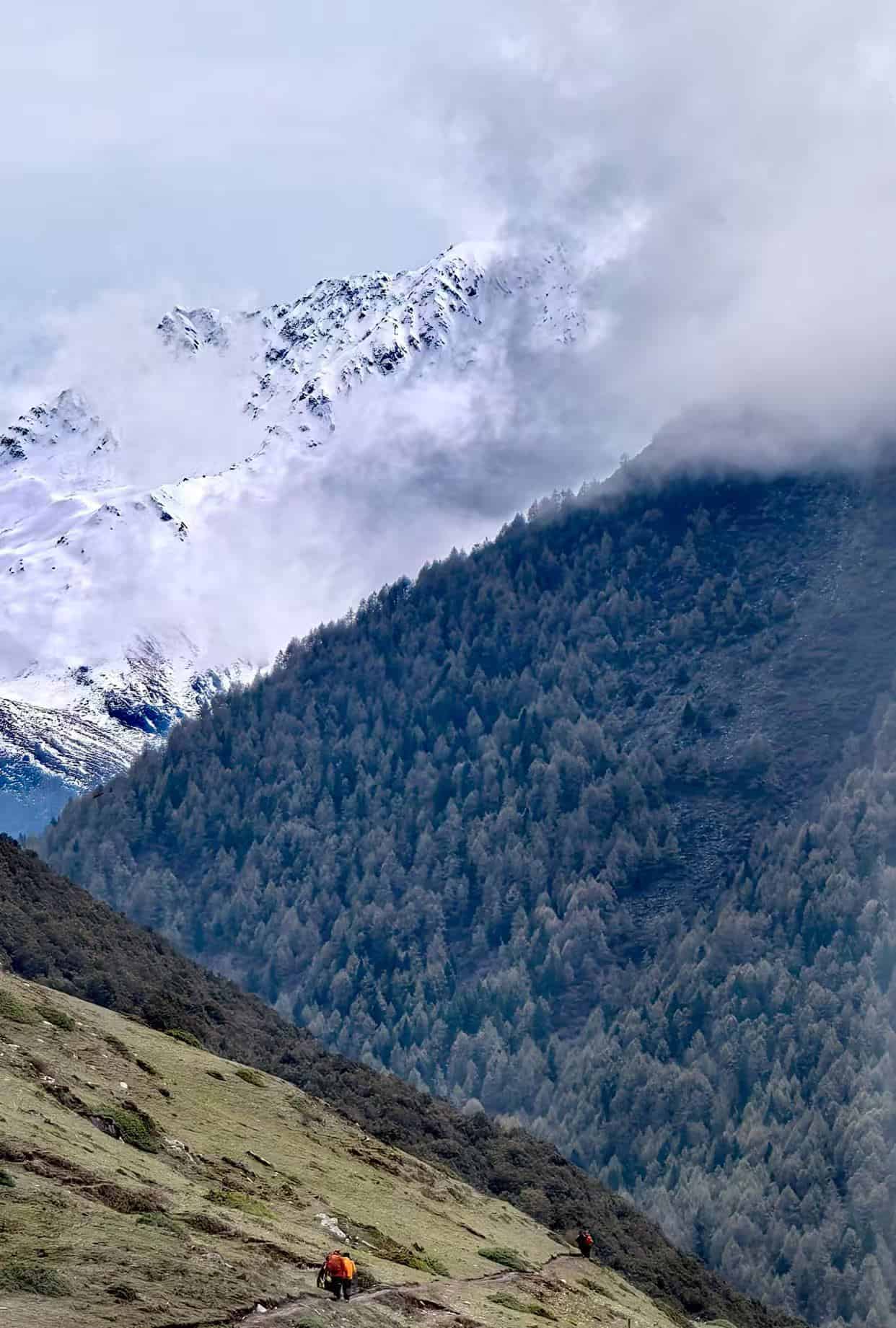 Expedition leader with specialized hiking gear overlooking the pristine snow-capped peaks and sea of clouds in the Hengduan Mountains. A remote and hidden alpine paradise.