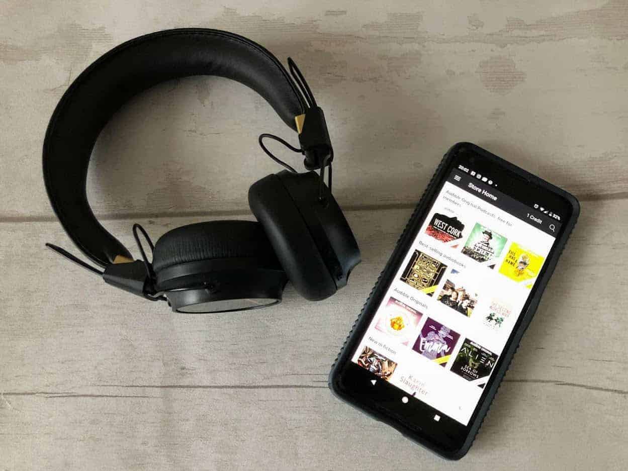 Black headphones and black smartphone on wooden background