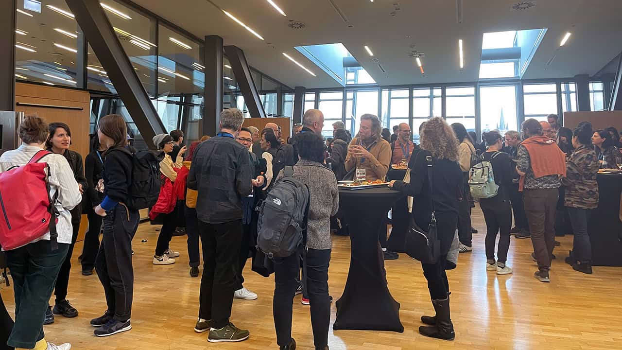 Participants during PoM chatting around cocktail tables.