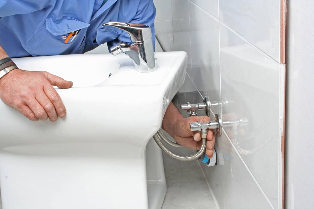 plumber installing standalone traditional bidet basin