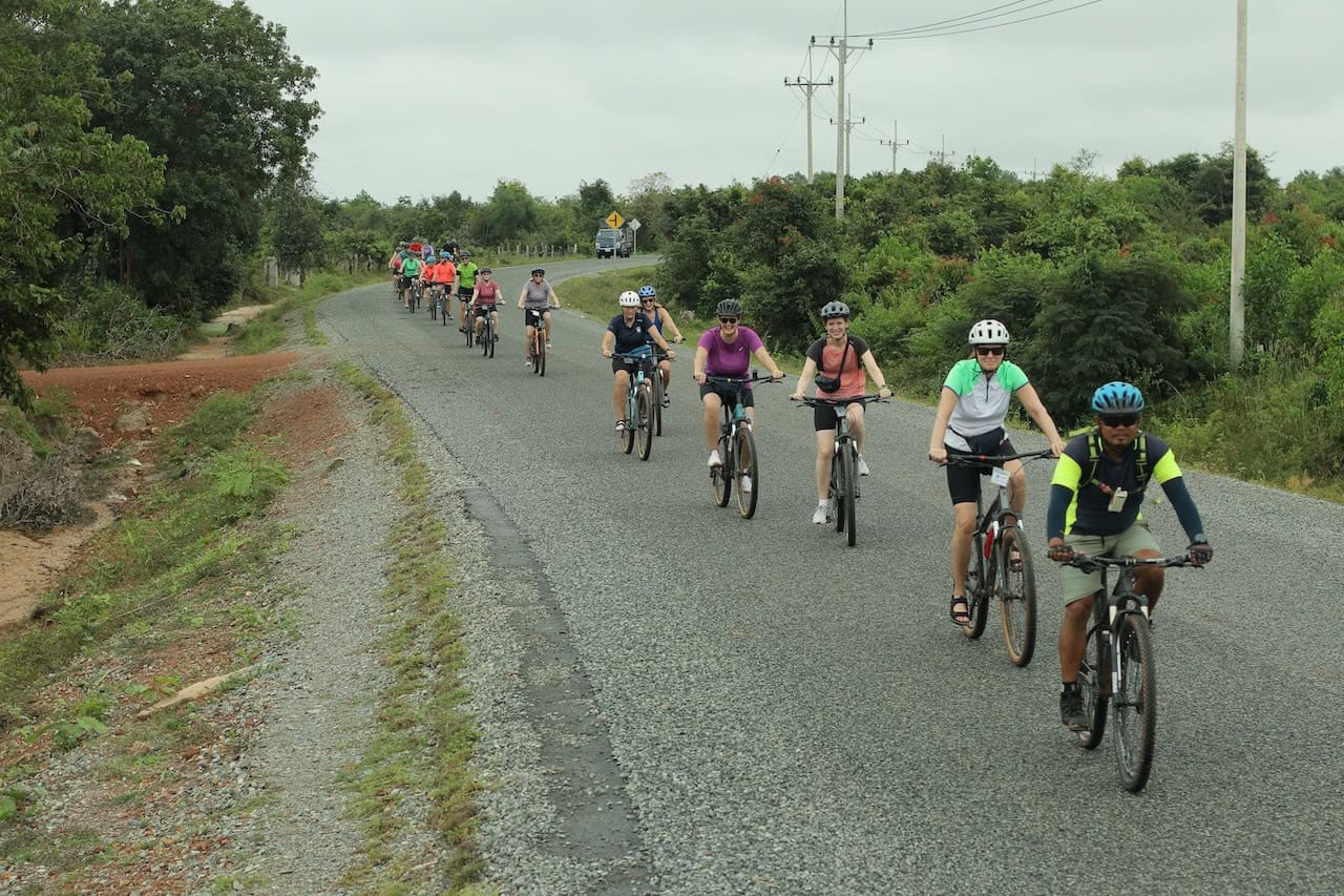 Cyclists traveling through Thailand, Cambodia, and Vietnam on a Southeast Asia cycling tour, riding scenic backroads, rural villages, rice fields, and cultural landscapes across Indochina.