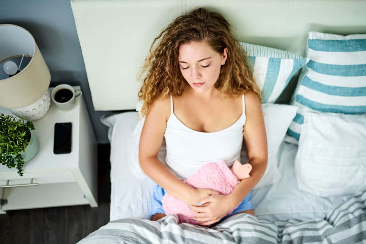 Women in bed with stomach pain