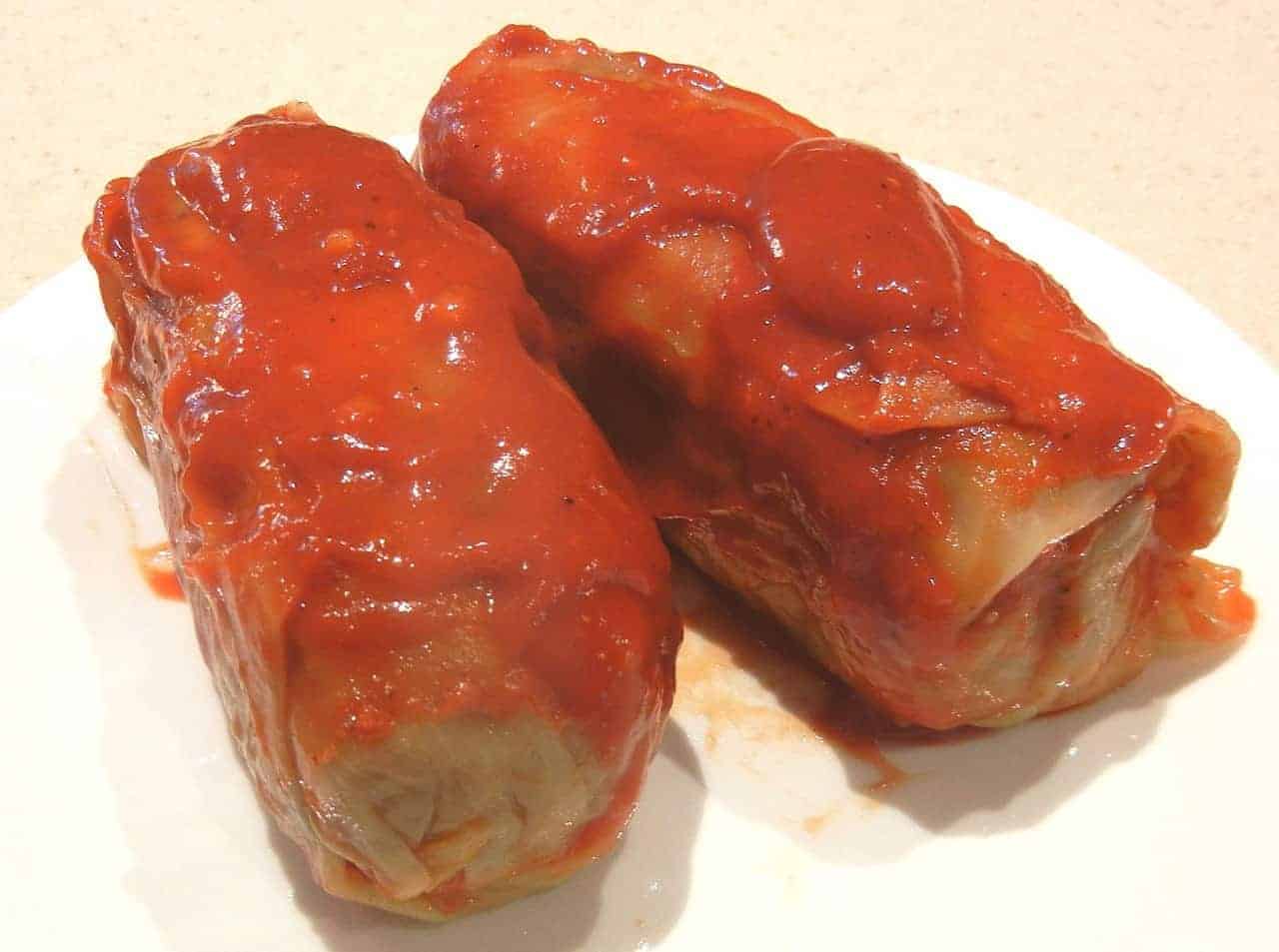 Authentic Polish golumpki recipe showcased with cabbage rolls and ketchup on a plate.