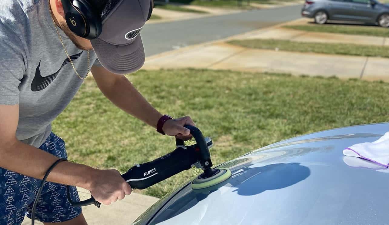 Professional detailer using Rupes polisher for paint correction on a car in Charlotte
