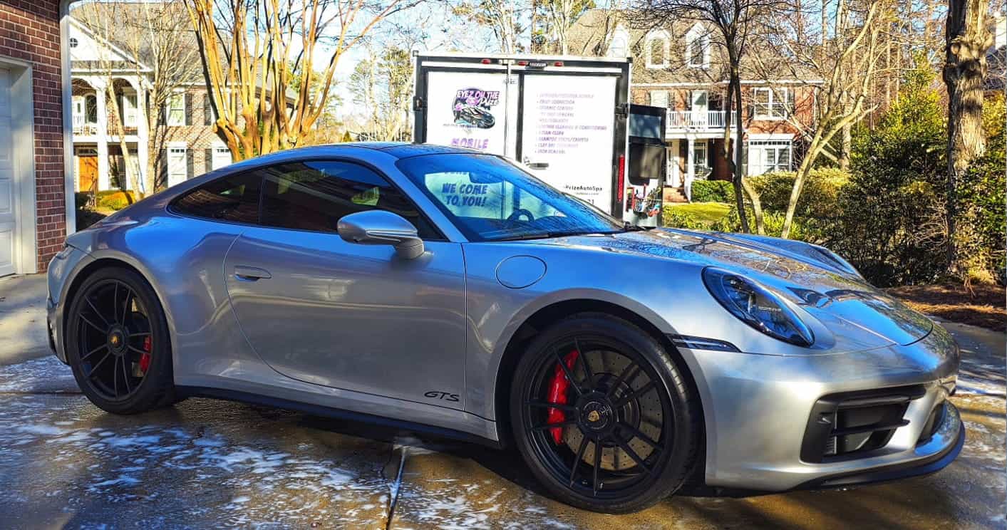 Luxury sports car receiving professional auto detailing service in Charlotte NC driveway