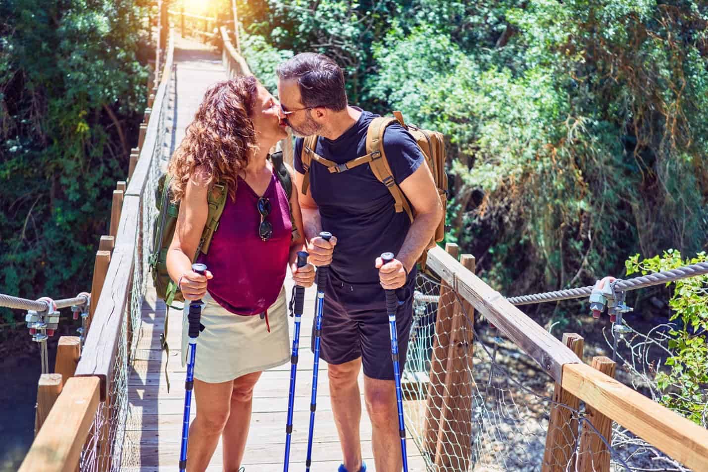 Couple kissing on a walking bridge over a gorge - two great relationship-building activities.
