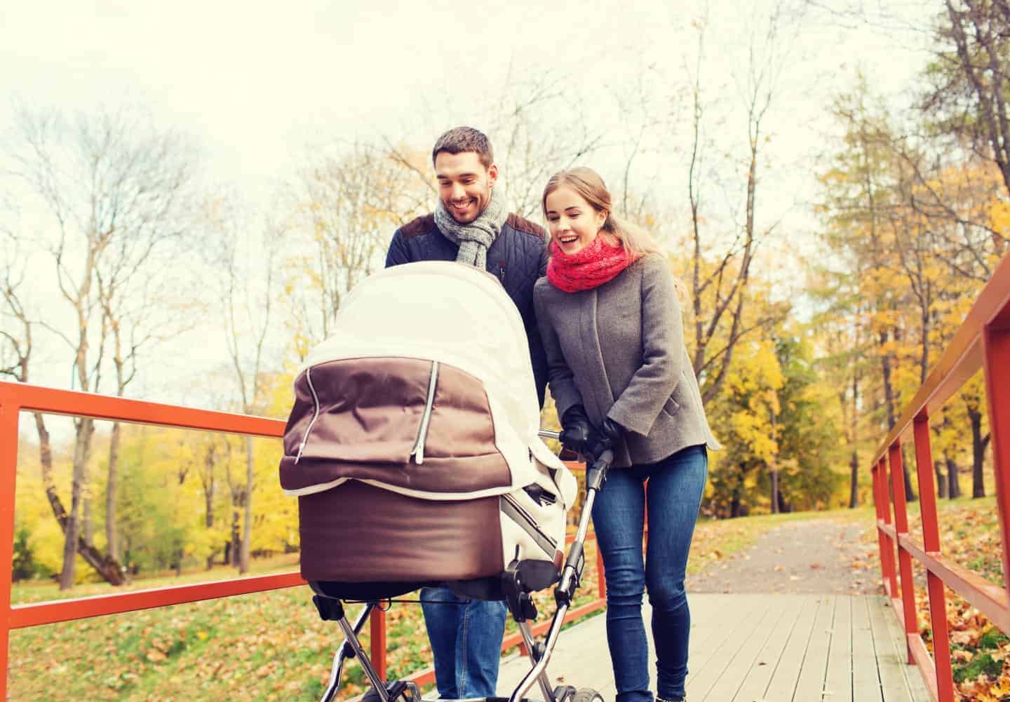 Couple walking in the fresh air with their baby in a pram