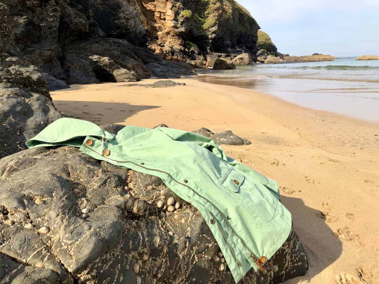 Lighthouse Clothing waterproof raincoat on a rock on the beach