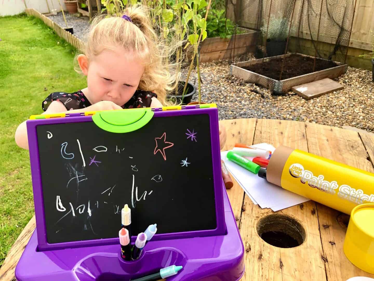 L deep in thought painting on her Little Brian Mini Art Station