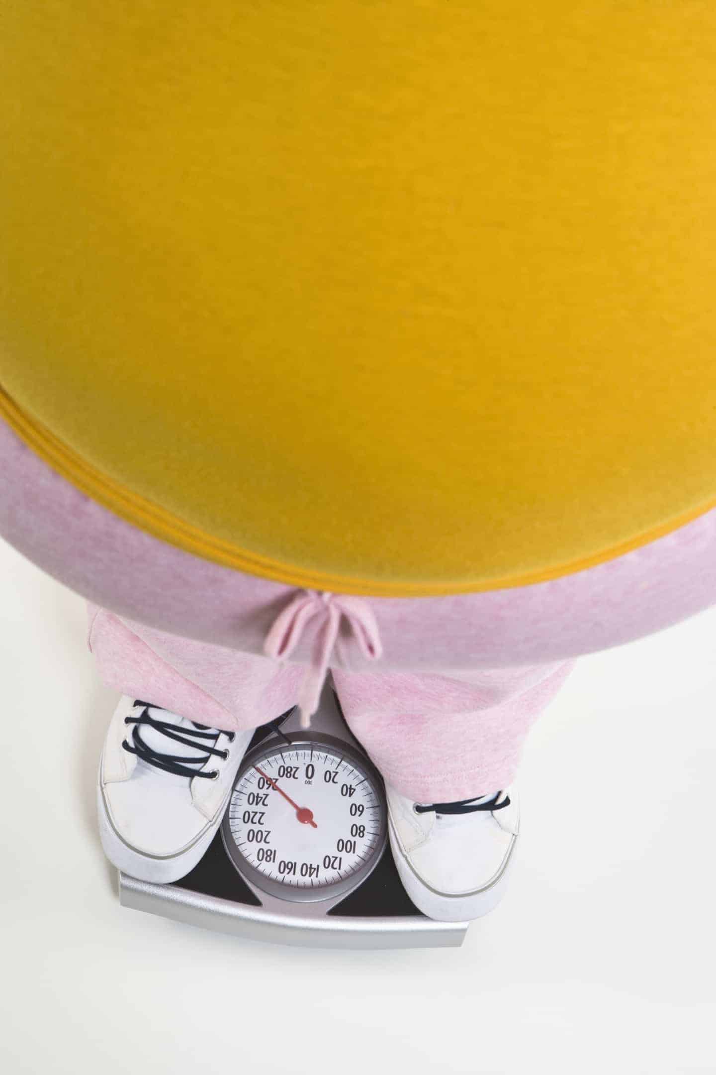 Person standing on bathroom scale, low section
